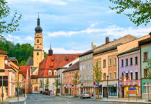 Viele bunte, alte Häuser sowie eine Kirche stehen im Zentrum einer kleinen Stadt. Der Ort ist ein schönes Ausflugsziel für Touristen. Besucher kennen die Straße, denn sie ist sehr berühmt.