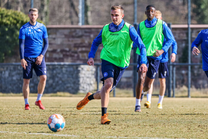 Die Fußballprofis des Karlsruher SC trainieren gemeinsam. Auch alle Neuzugänge sind dabei. Der Trainer überwacht das Fußballtraining auf dem Platz und gibt Anweisungen.