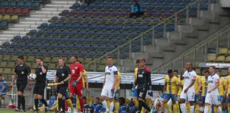 Die Spieler des Karlsruher SC laufen in ein leeres Stadion zu einem Spiel oder einem Testspiel in der Bundesliga auf. Daneben stehen die Trainer des KSC ebenso wie die Schiedsrichter des Tages.