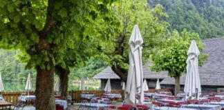 Ein Biergarten ist völlig leer. Im Restaurant sind keine Gäste mehr, es hat wohl geschlossen. Die Terrasse wirkt verwaist, es liegen aber noch Tischdecken auf den Tischen.