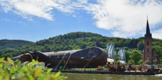 Ein altes, ausgemustertes U-Boot wird über einen Fluss transportiert. Das Boot ist eine echte Attraktion und soll in einem Museum ausgestellt werden.