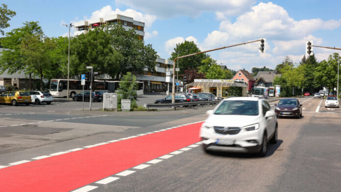 Rote Fahrbahnmarkierungen auf der Straße verweisen auf die Fahrradstraßen, die an den Autos entlang führen und für noch mehr Sicherheit sorgen sollen.