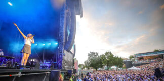 Das Fest in Karlsruhe im Jahr 2024 mit Tausenden von Besuchern. Auf der Bühne steht in blauem Licht eine Sängerin und performt.