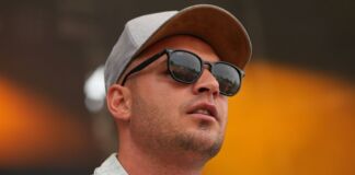 Pietro Lombardi schaut nachdenklich, er trägt eine Cap und eine Sonnenbrille. Bei diesem Foto steht er gerade auf der Bühne von einem open Air vor seinen Fans.