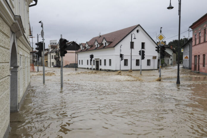 In einer kleinen Stadt ist ein Hochwasserereignis passiert. Die ganze Ortschaft steht unter Wasser und die Straßen und Zugänge zu den Häusern sind durch das bräunliche Wasser unpassierbar.