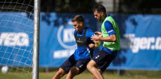 Zwei Spieler des Karlsruher SC kämpfen gemeinsam um den Ball. Sie befinden sich beide im Training und in Vorbereitung auf die Spiele der zweiten Bundesliga. Zu sehen sind Marcel Beifus und Luca Pfeiffer.