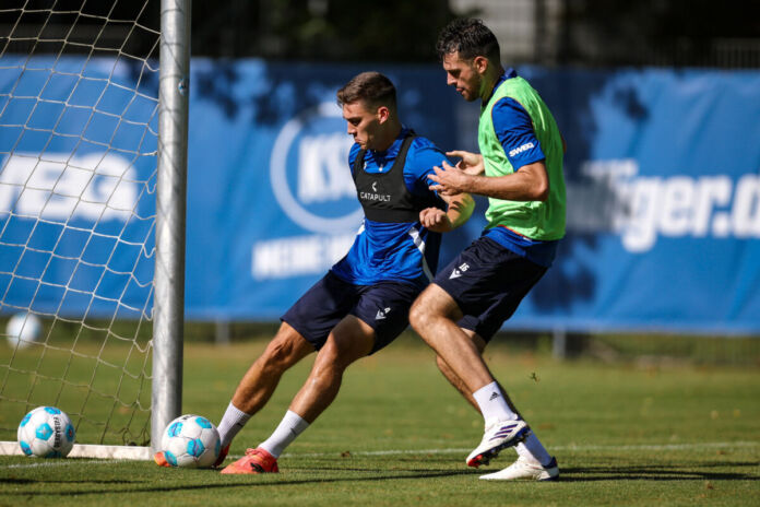 Zwei Spieler des Karlsruher SC kämpfen gemeinsam um den Ball. Sie befinden sich beide im Training und in Vorbereitung auf die Spiele der zweiten Bundesliga. Zu sehen sind Marcel Beifus und Luca Pfeiffer.