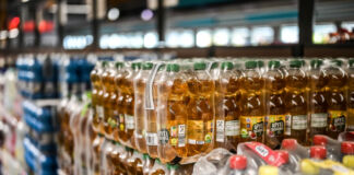 In einer Aldi-Filiale stehen viele Träger unterschiedlicher Getränke auf Paletten gestapelt über- und nebeneinander. Im Vordergrund steht Apfelschorle in kleinen Flaschen. Im Hintergrund stehen verschiedene Sorten von Wasser. Alle Aldi-Filialen sind nun von dem Stopp der Produktion von Getränken betroffen.