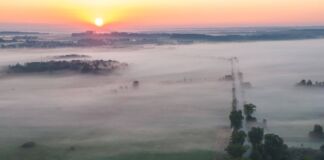 Ein Sonnenuntergang taucht einen wunderschönen See in sanftes Licht. Das Moor ist in Nebel gehüllt und eine einzigartige Attraktion für Touristen.