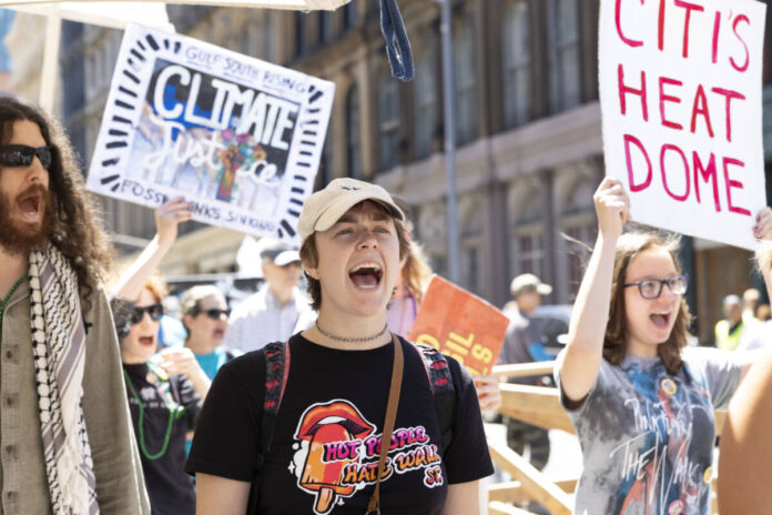 Klima-Aktivisten ziehen mit Plakaten durch die Straßen und protestieren. Sie gehen durch die Innenstadt und planen eine neue Aktion für den Umweltschutz.