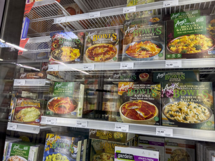 Im Kühlregal eines Discounters oder Supermarktes steht eine große Auswahl an vegetarischen und veganen Fertiggerichten wie Bowls und Aufläufe.