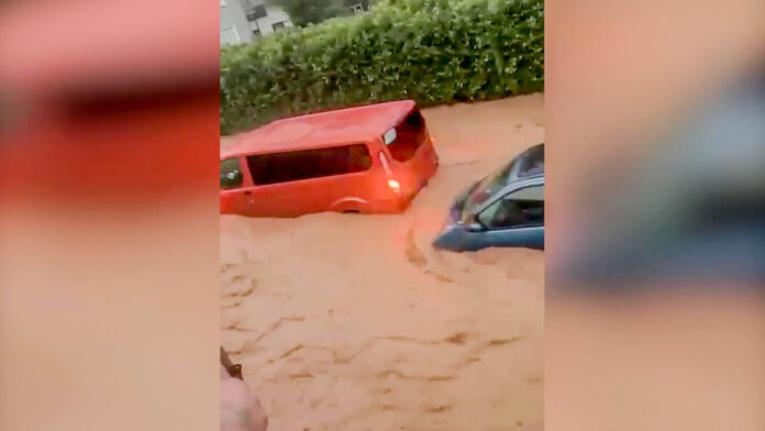 Die tosenden Wassermassen reißen mehrere Fahrzeuge mit sich. Die Menschen sind machtlos, sie können ihre Autos nicht mehr aus den Fluten retten.