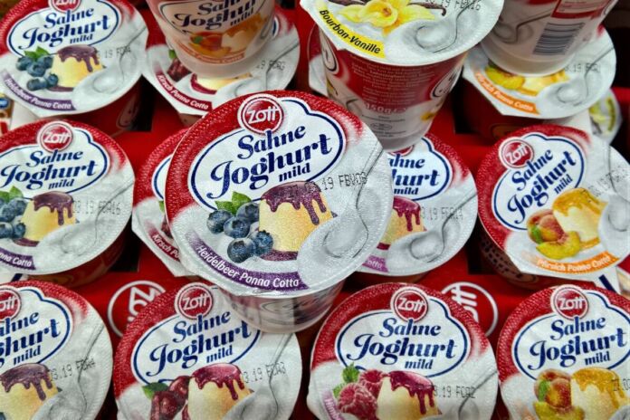 In einer Palette befinden sich verschiedene Sorten von Sahnejoghurt der Marke Zott. Das Unternehmen ist dafür bekannt, dass seine Produkte ausschließlich mit Milch und Milchprodukten produziert werden. Doch jetzt soll Zott ebenfalls auf vegan umstellen.