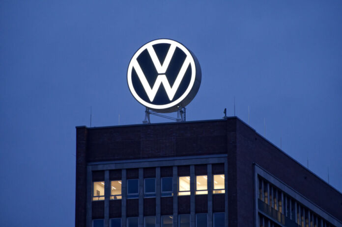 Die Volkswagen AG-Zentrale in Wolfsburg. Am dunklen Himmel erstrahlt das Logo des größten deutschen Autobauers. Der Hauptsitz in Wolfsburg ist das Herzstück von VW.