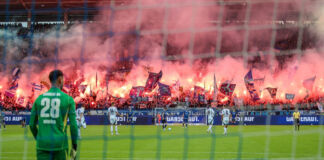 Die Fans zünden im Wildparkstadion Pyrotechnik und erleuchten damit die gesamte Tribüne. Während auf dem Rasen ein Spiel läuft, gibt das Ganze ein gefährliches Bild ab.