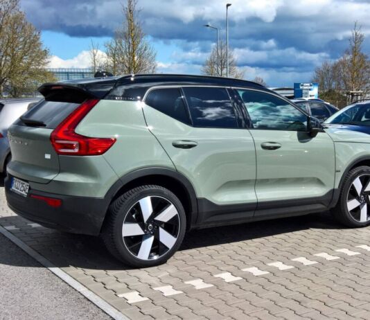 Ein silbernes Elektroauto steht auf einem Parkplatz. Es handelt sich um einen SUV, der elektrisch betrieben ist. Das E-Auto ist ein großer Volvo.