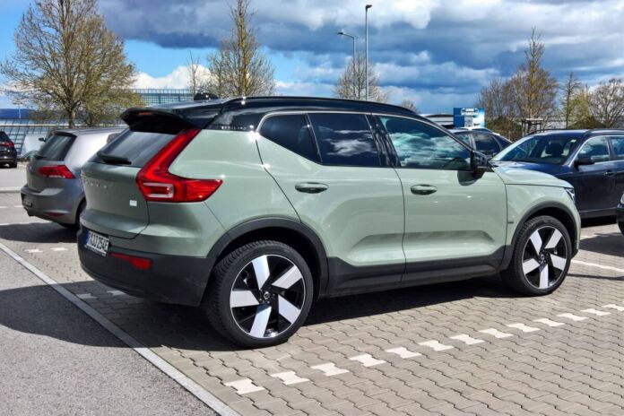 Ein silbernes Elektroauto steht auf einem Parkplatz. Es handelt sich um einen SUV, der elektrisch betrieben ist. Das E-Auto ist ein großer Volvo.