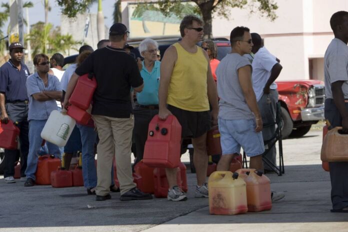 Die Bürger stehen in sommerlicher Kleidung in der Schlange und warten darauf, ihre Kanister mit frischem Leitungswasser und Trinkwasser zu befüllen.