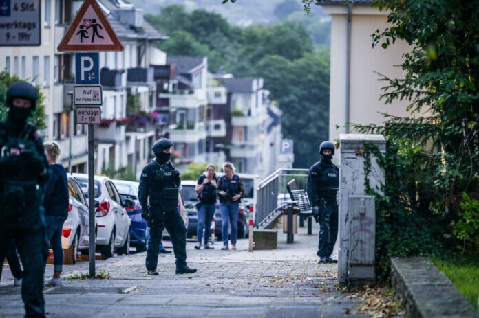 Mehrere Beamte der Polizei und des SEK sind im Einsatz. Sie evakuieren ein Gebäude, um Menschen zu schützen. Dabei kommt es auch zu Festnahmen.