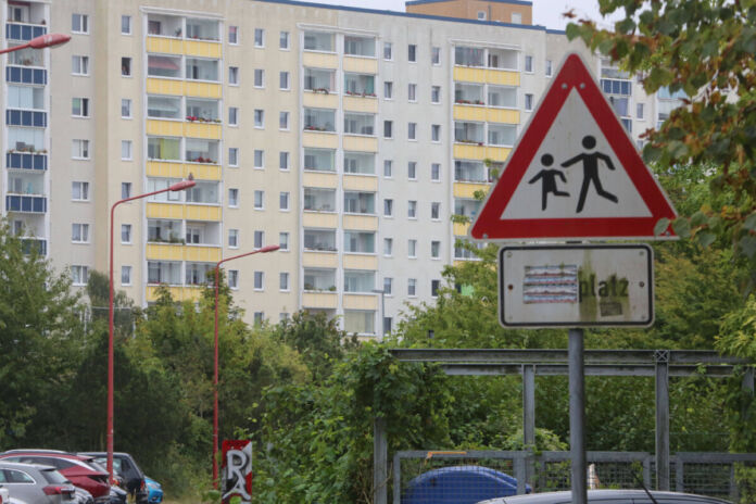 In einem Stadtteil stehen viele große Hochhäuser mit zahlreichen kleinen Wohnungen. Der Stadtteil ist grau und eher hässlich. Die Stadt ist nicht beliebt bei den Menschen.