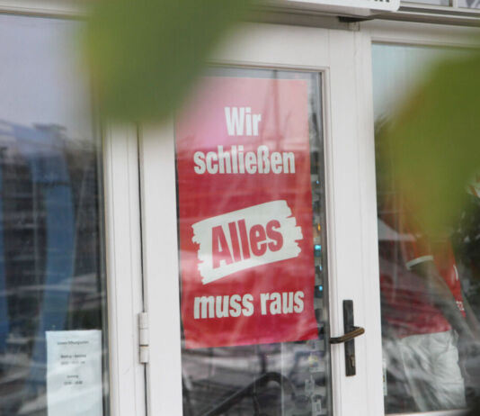 Die Türen eines Geschäfts sind geschlossen. Rot-weiße Schilder in der Tür und den Fenstern weisen darauf hin, dass der Laden bald schließt. Auf den Plakaten ist zu lesen "Wir schließen. Alles muss raus." Ein weiteres deutsches Traditionsunternehmen ist jetzt insolvent.